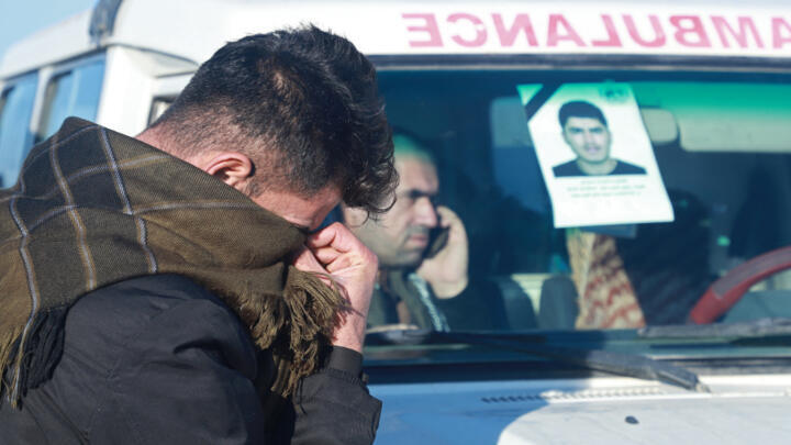 A relative of one of 16 Iraqi Kurds killed after their boat sank in the English Channel attends their funeral in Raniya, east of Arbil, the capital of Iraq's northern autonomous Kurdish region, on December 26, 2021.